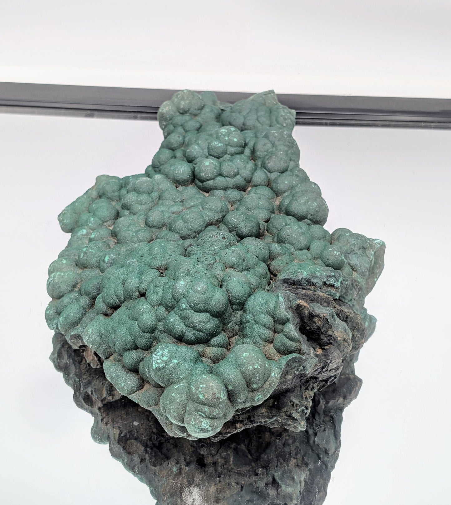 Botryoidal malachite crystal adorned with sparkling quartz druzy.