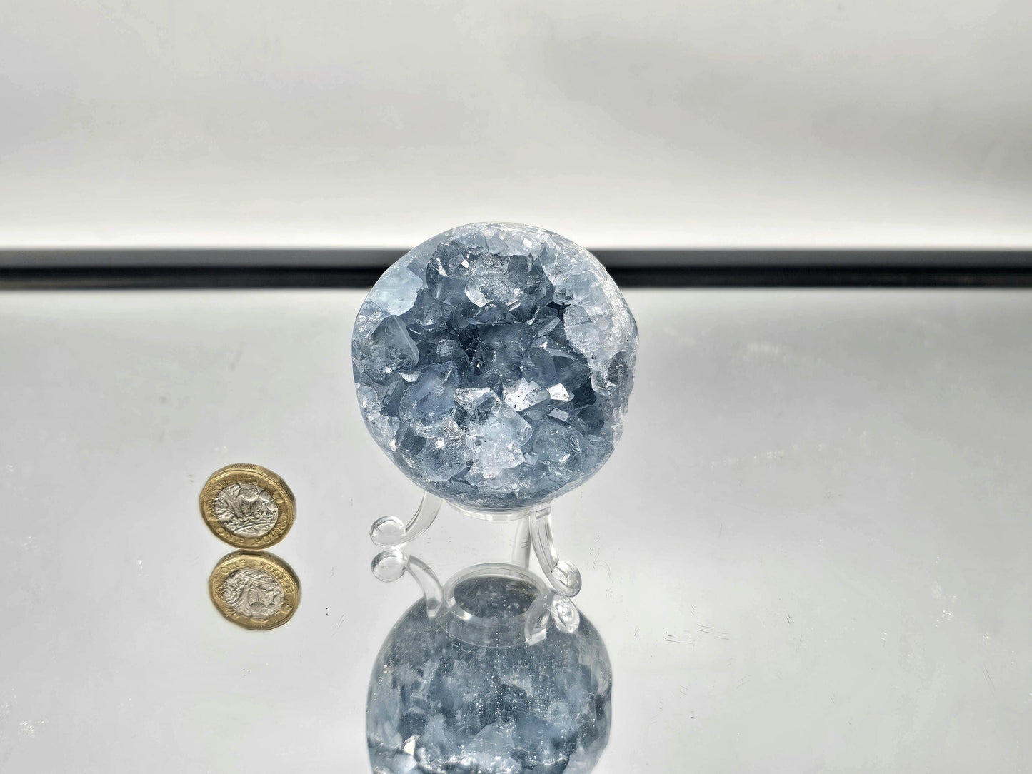 Celestite Sphere displayed as part of a crystal collection.