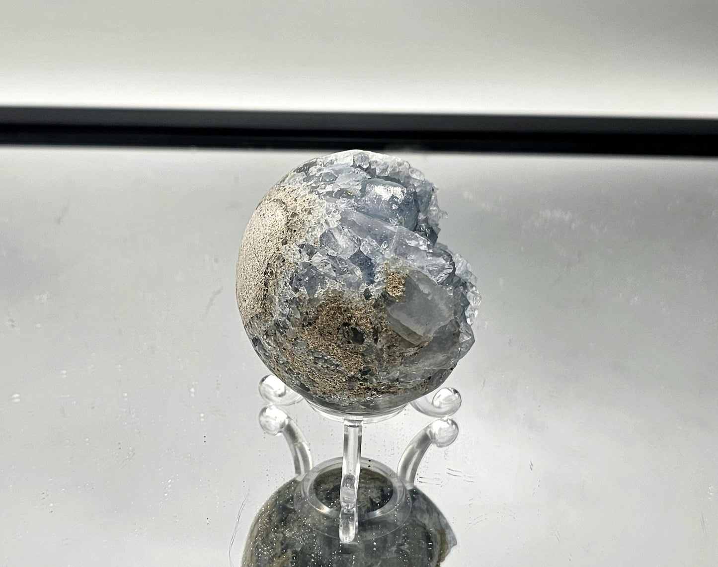 Natural Celestite sphere showcasing fine blue crystal points for elegant décor.