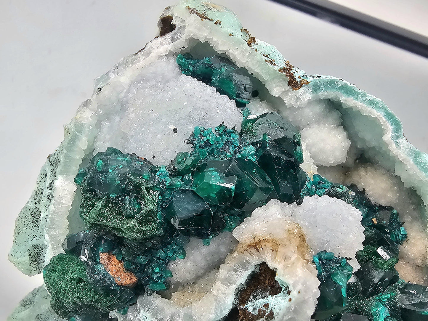 Close-up of Dioptase on Quartz matrix, highlighting the intricate crystalline details and vivid green color.