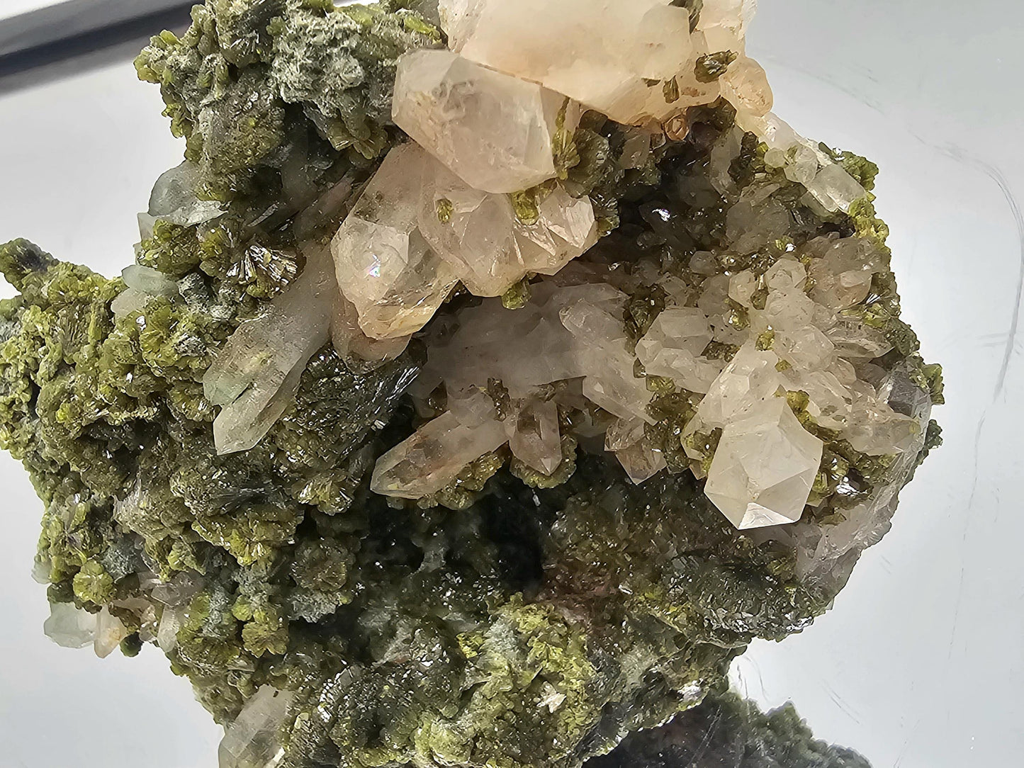 Close-up detail of pistachio-green Epidote crystal intertwined with quartz.