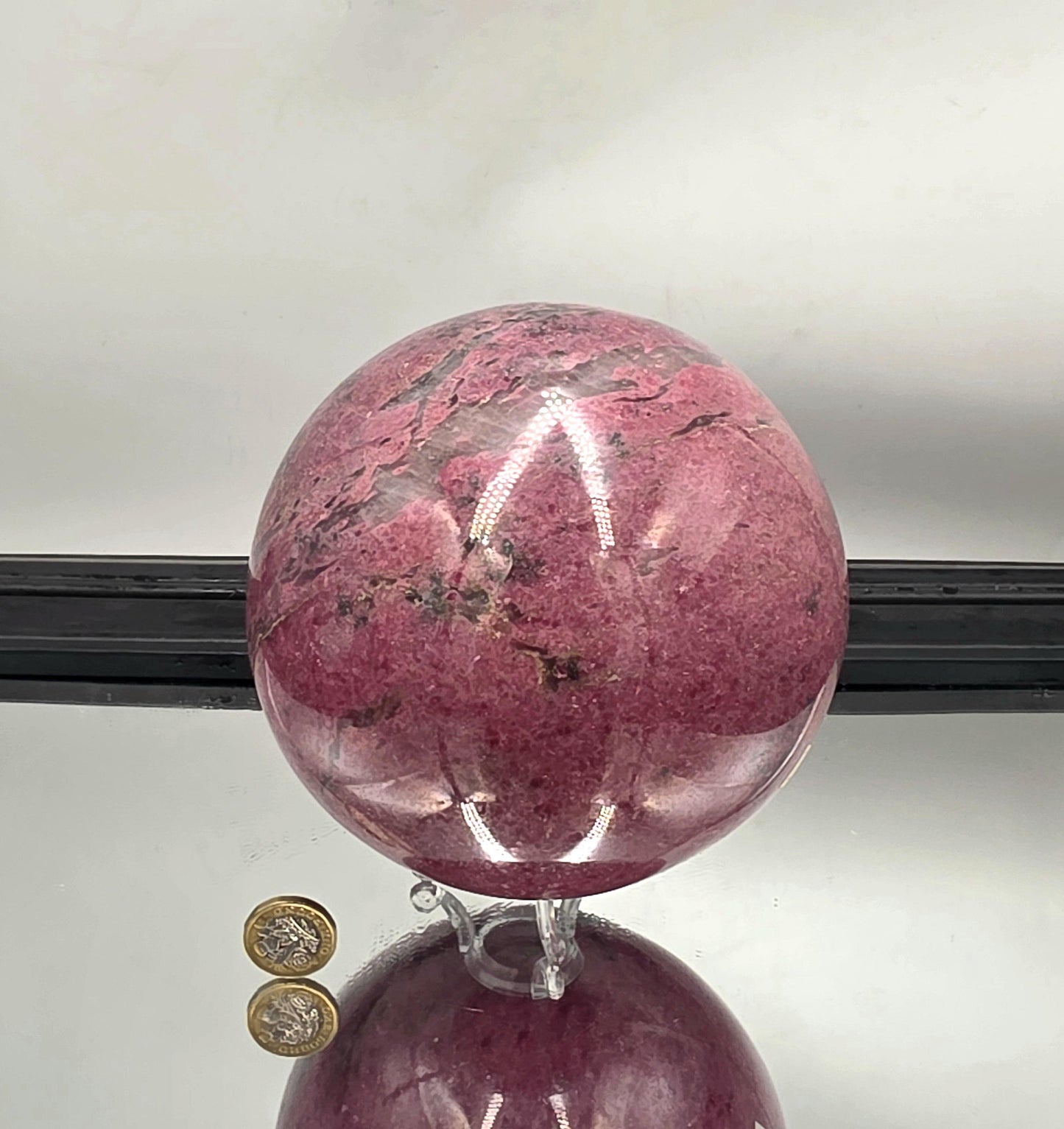 XL rhodonite sphere showcasing vivid pink and black contrasts.