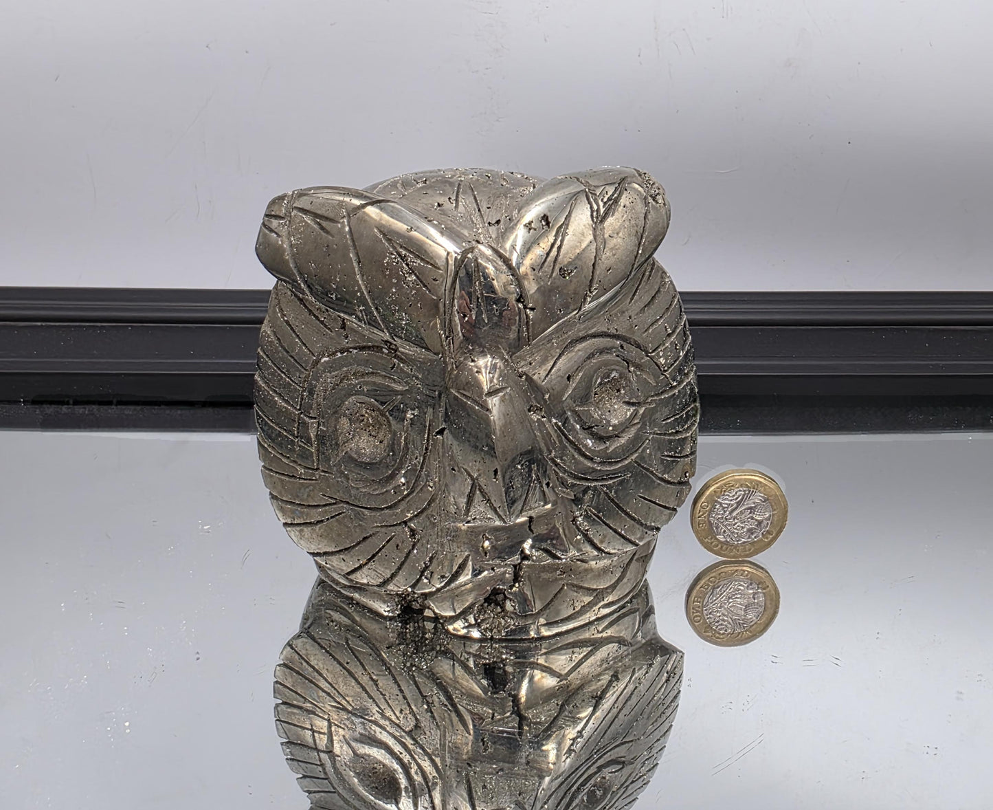 Close-up of natural Fool’s Gold owl carving