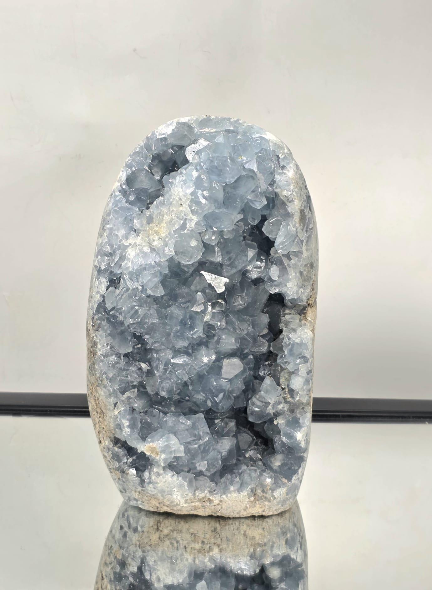 A large natural Celestite crystal freeform from Madagascar with shimmering sky-blue crystals and a smooth cut base.