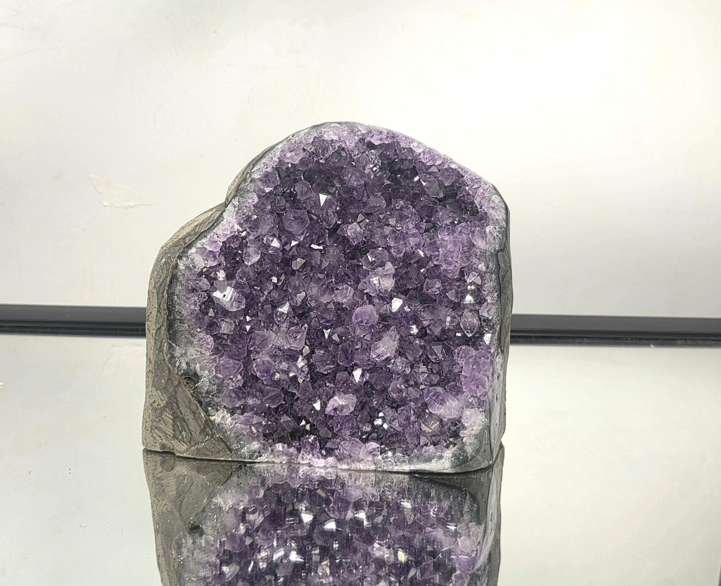 Large Uruguayan amethyst geode with deep purple crystals, natural quartz formation and display-ready cut base.