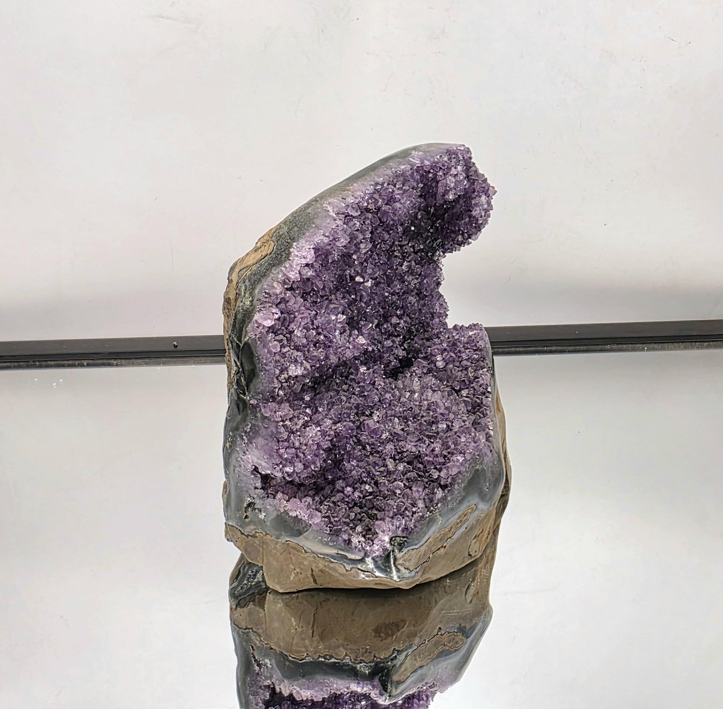 A polished Uruguayan Amethyst geode with natural beauty.