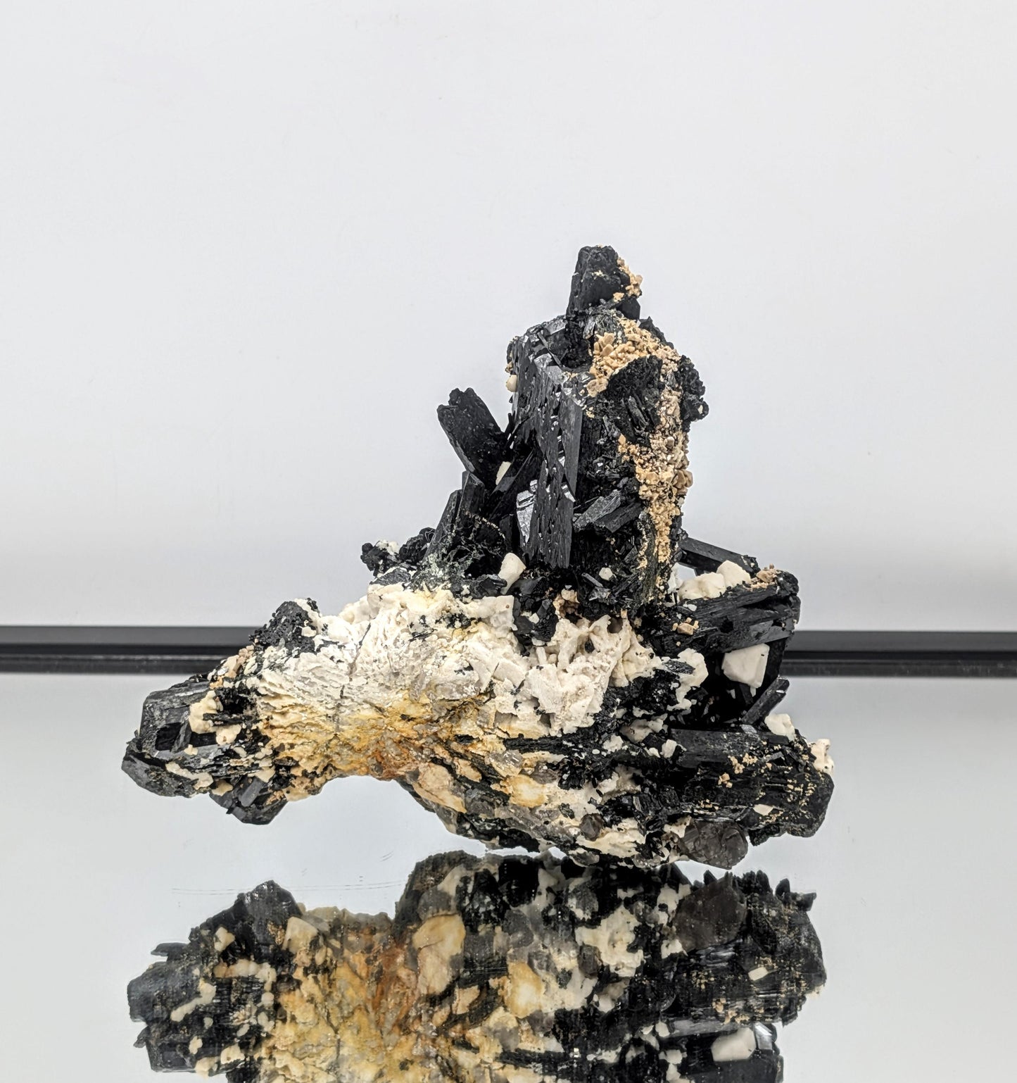 Feldspar matrix supporting dramatic dark and clear crystal growth.