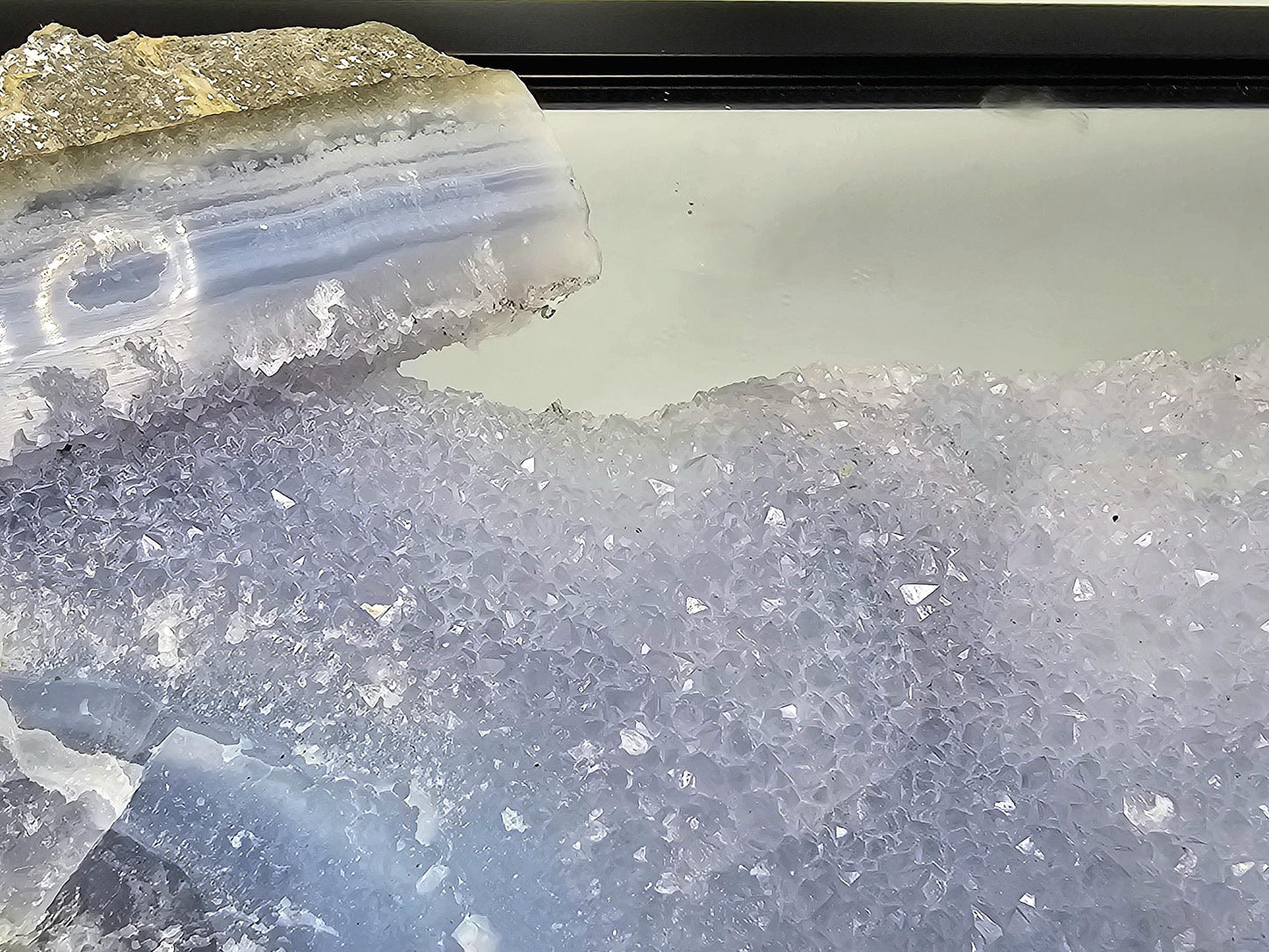 Raw and polished Blue Lace Agate geode enhancing the decor of a minimalist living space.