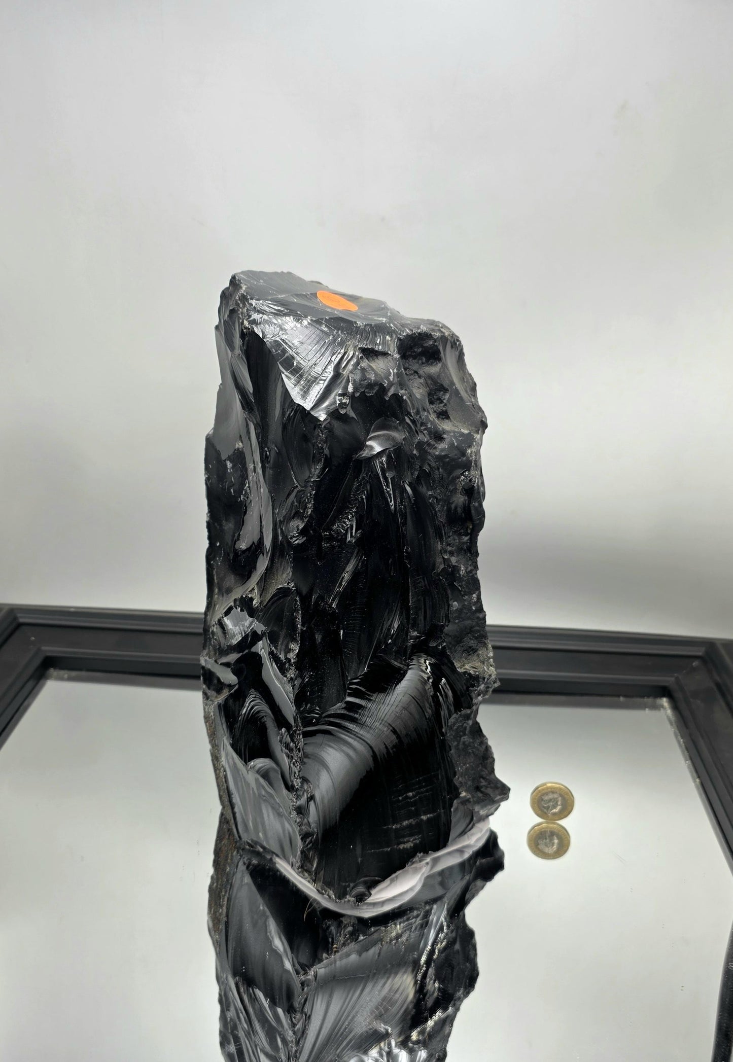 Raw volcanic glass Obsidian showing natural jagged edges and gloss.