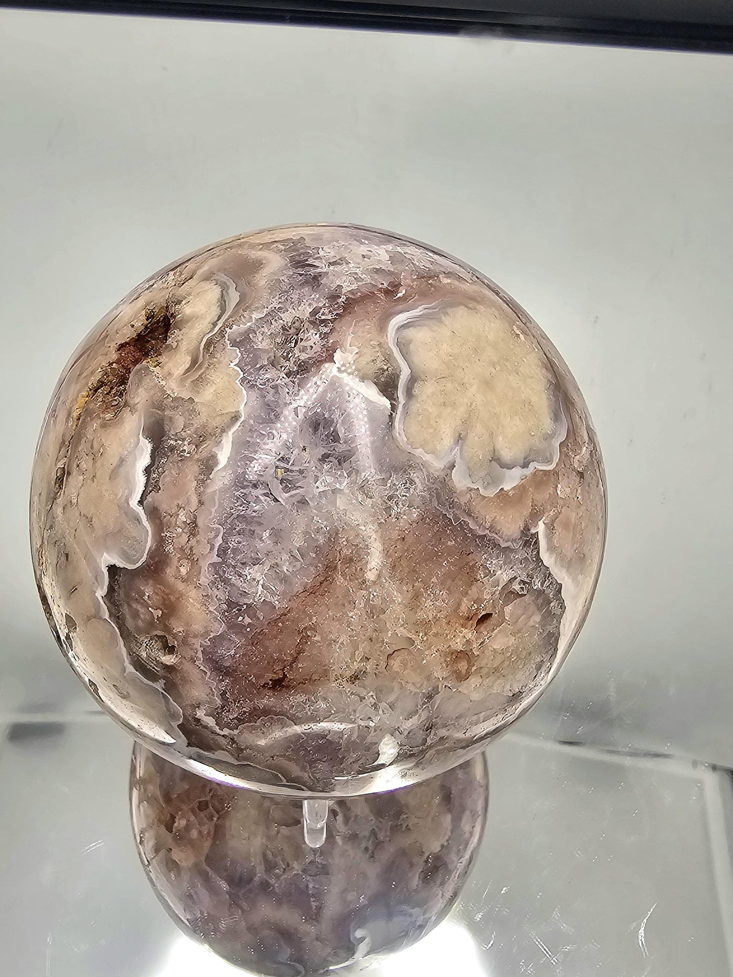 Stunning Sakura Flower Agate and Amethyst crystal sphere with flower-like details, perfect for any collection.