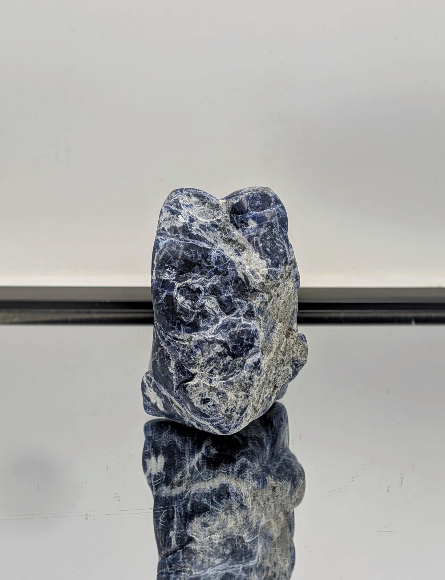 Partially polished Sodalite freeform crystal with raw, rough edges.