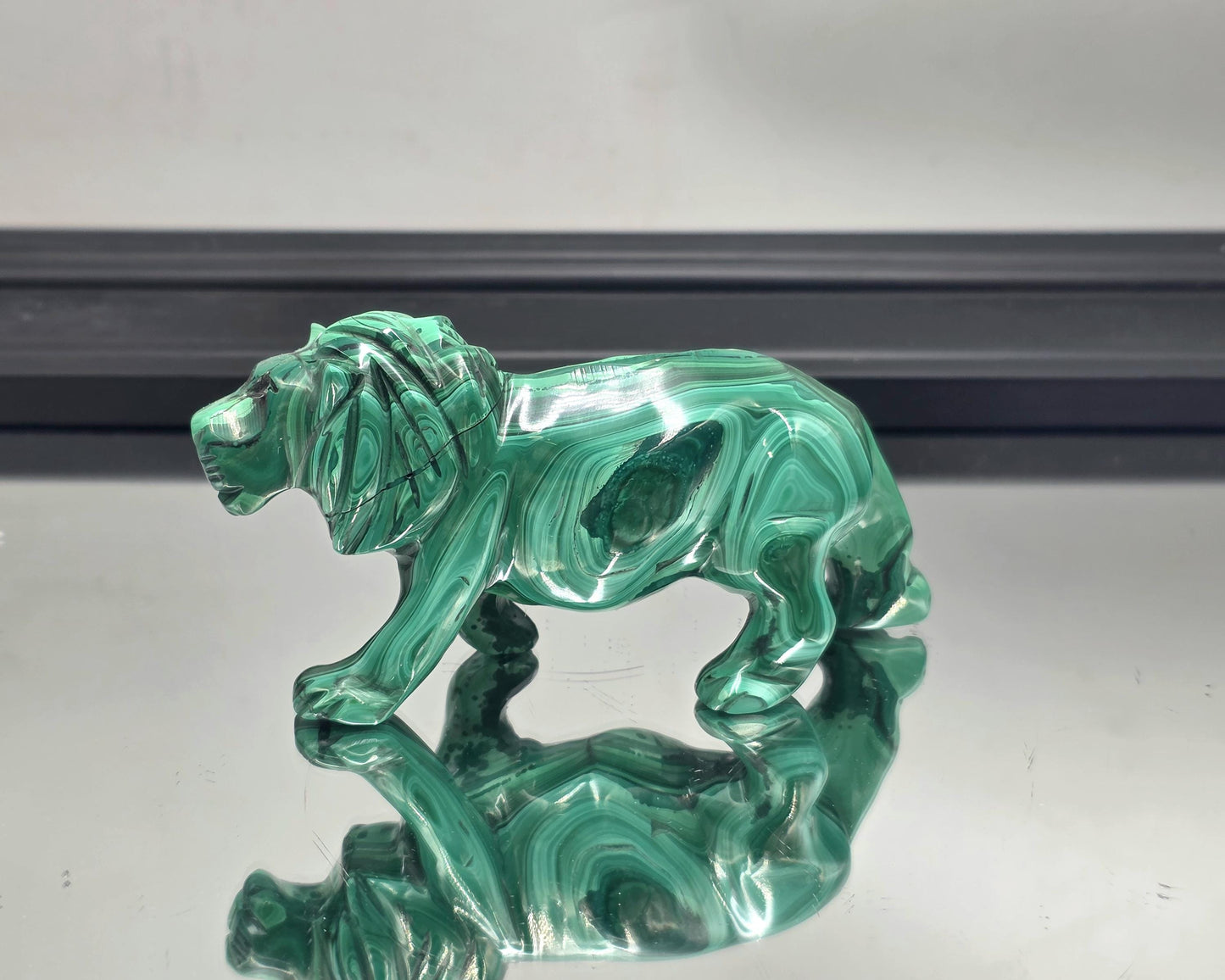 Stunning green tiger figure styled on a dark wood accent table.
