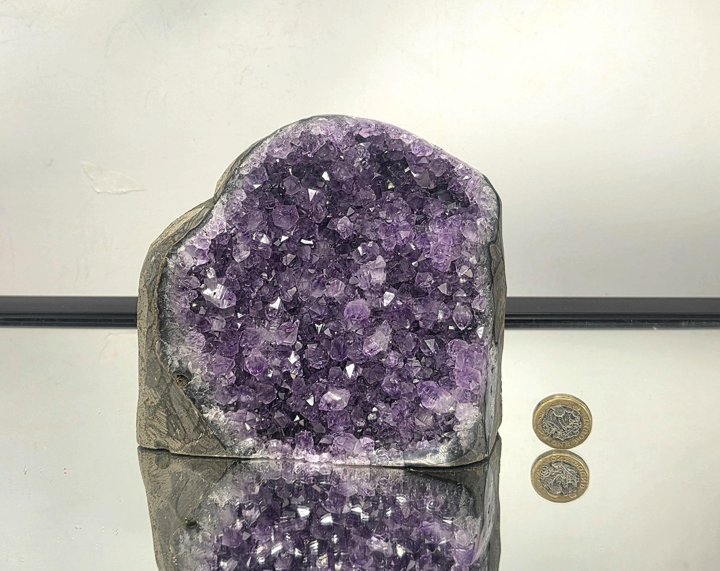 Side view of a large natural amethyst geode from Uruguay highlighting crystal depth and curved geode shape.