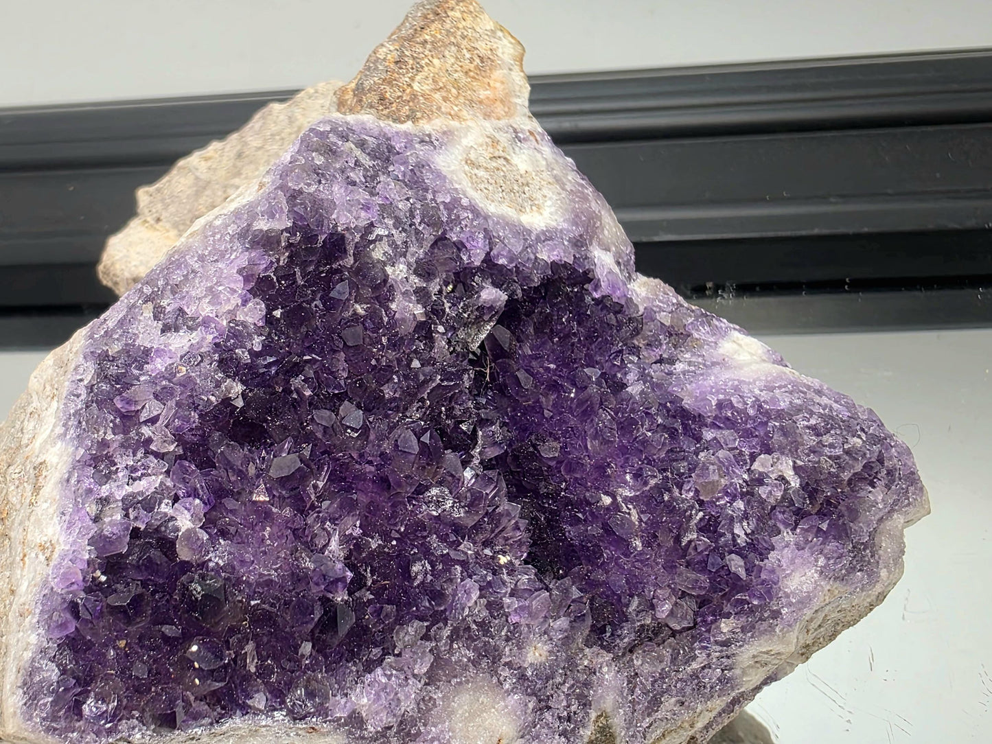 Dark violet Mapatizya amethyst cluster for display.