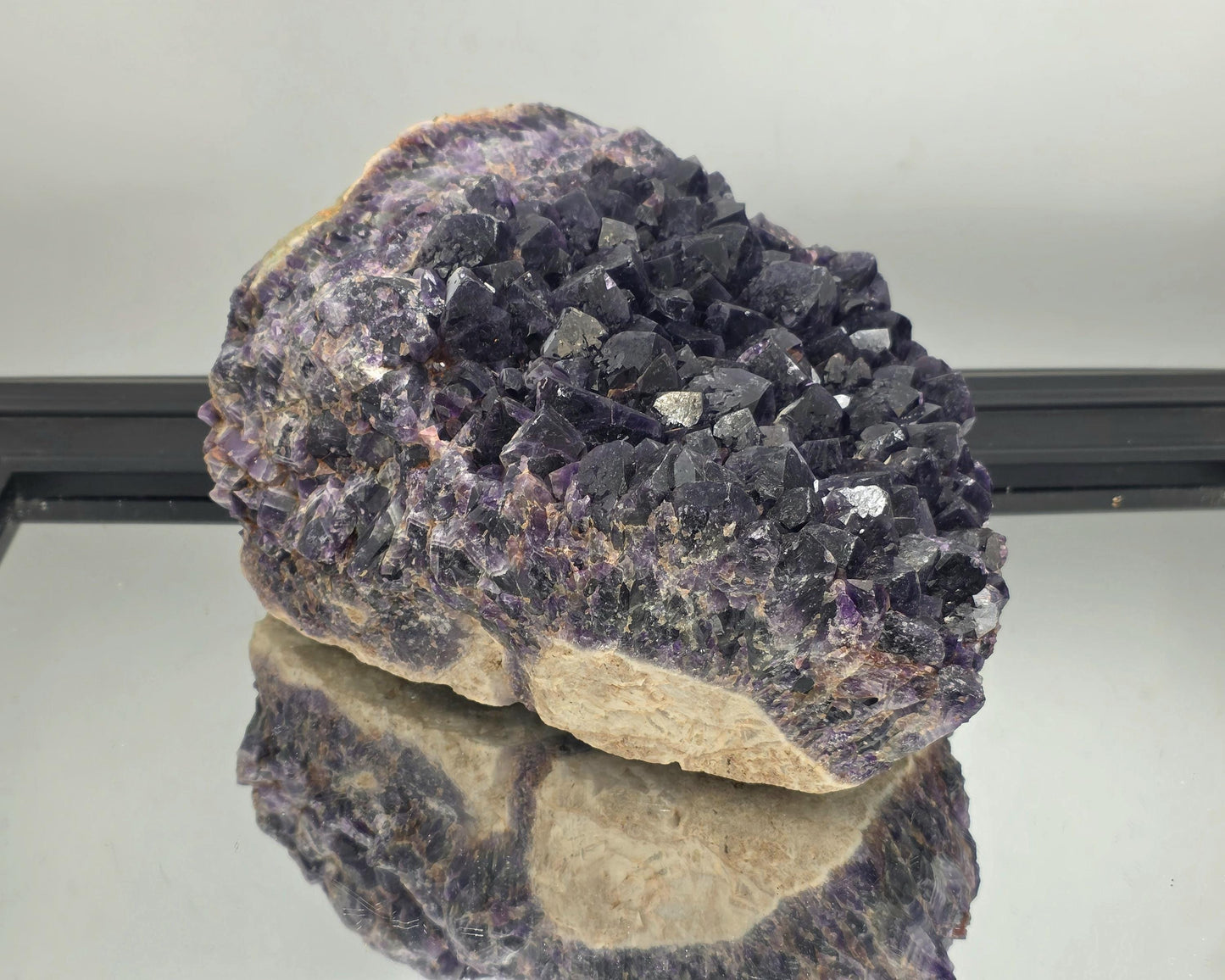 Natural Zambian amethyst cluster specimen with vibrant purple crystals.