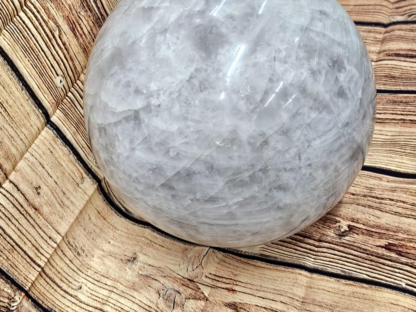Giant quartz crystal ball with unique veils and inclusions for collectors and enthusiasts.
