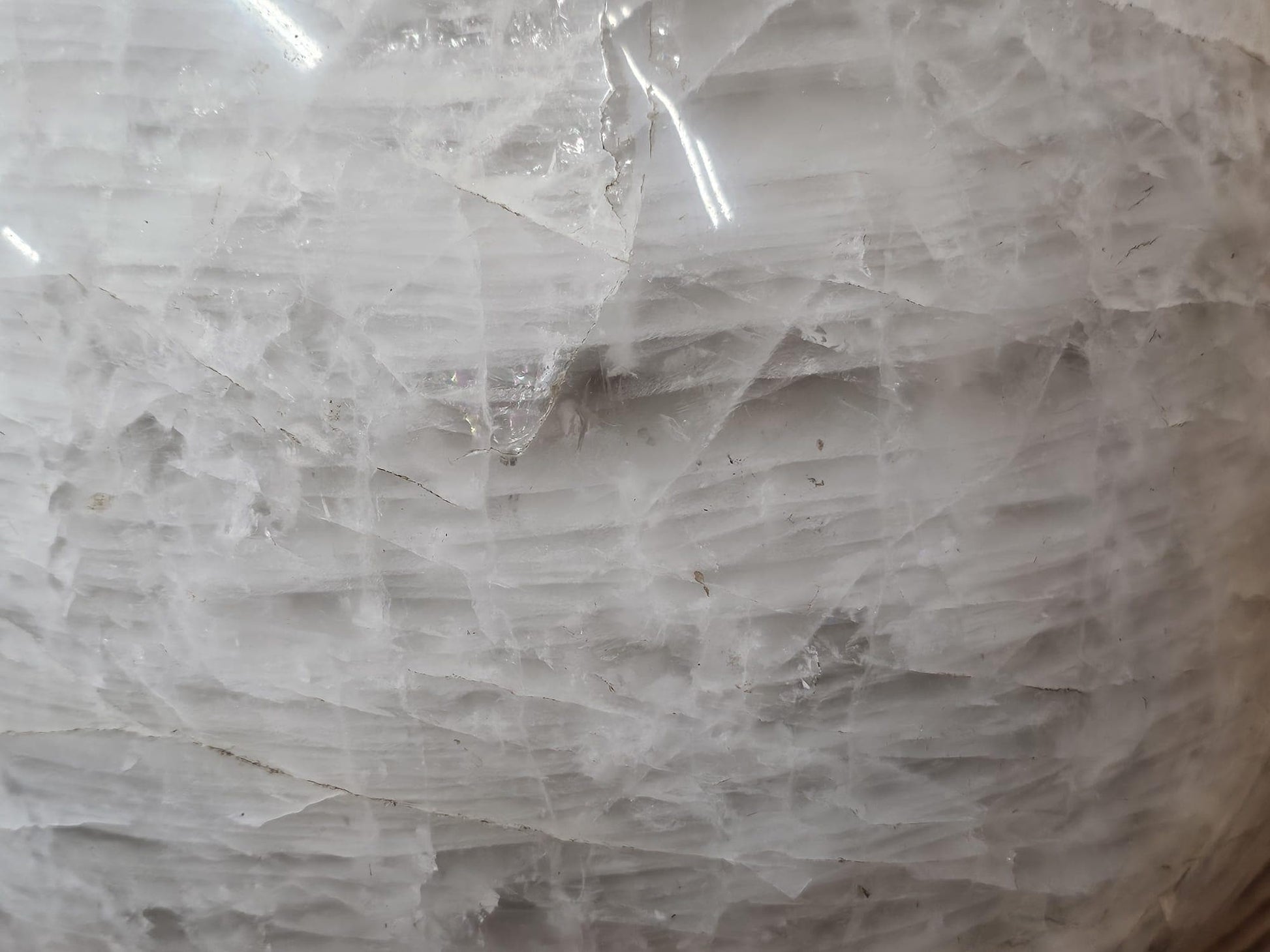 Massive natural quartz sphere with intricate veils and inclusions, ethically sourced from Madagascar.
