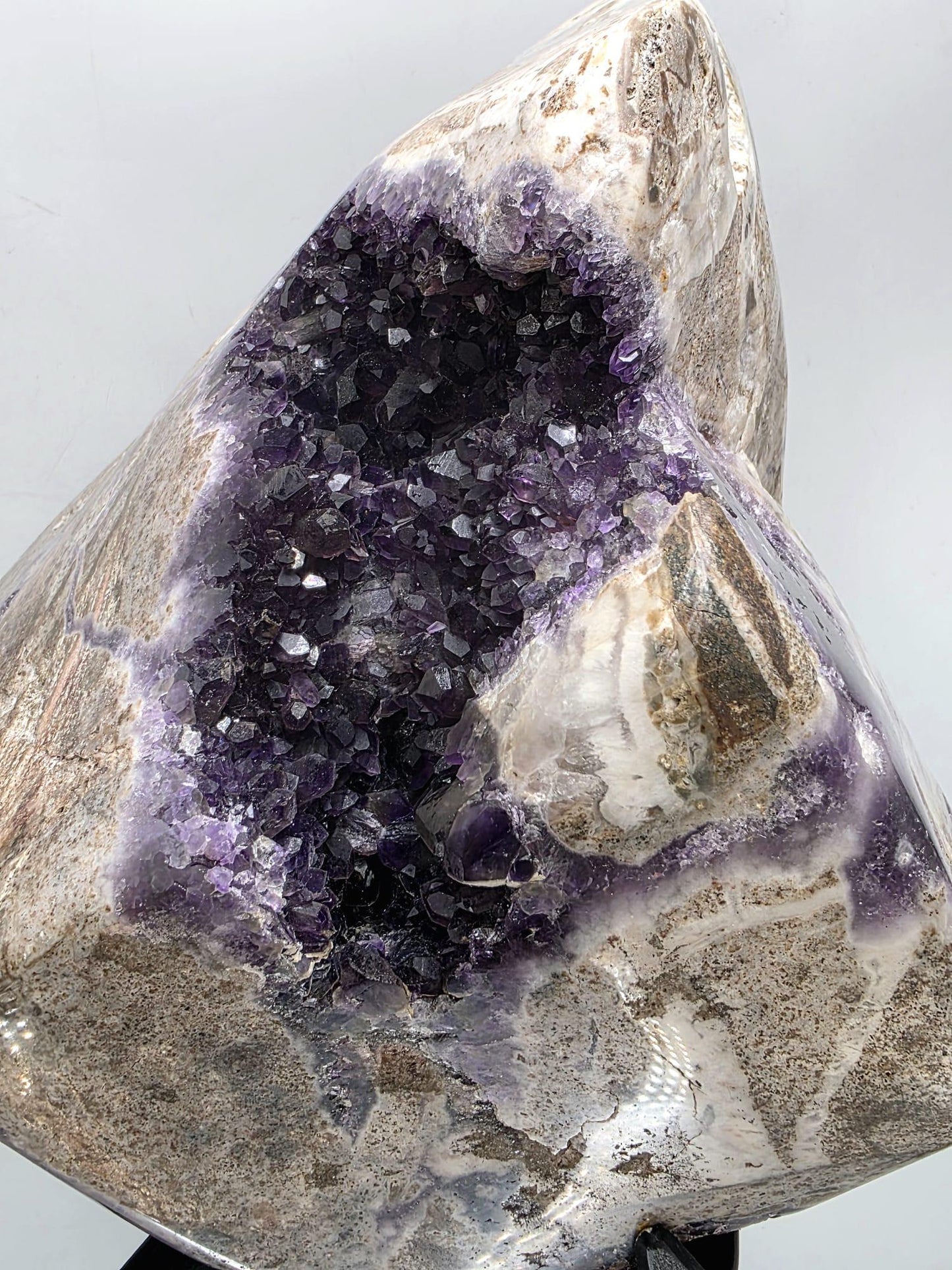 Amethyst display piece mounted on metal stand for presentation