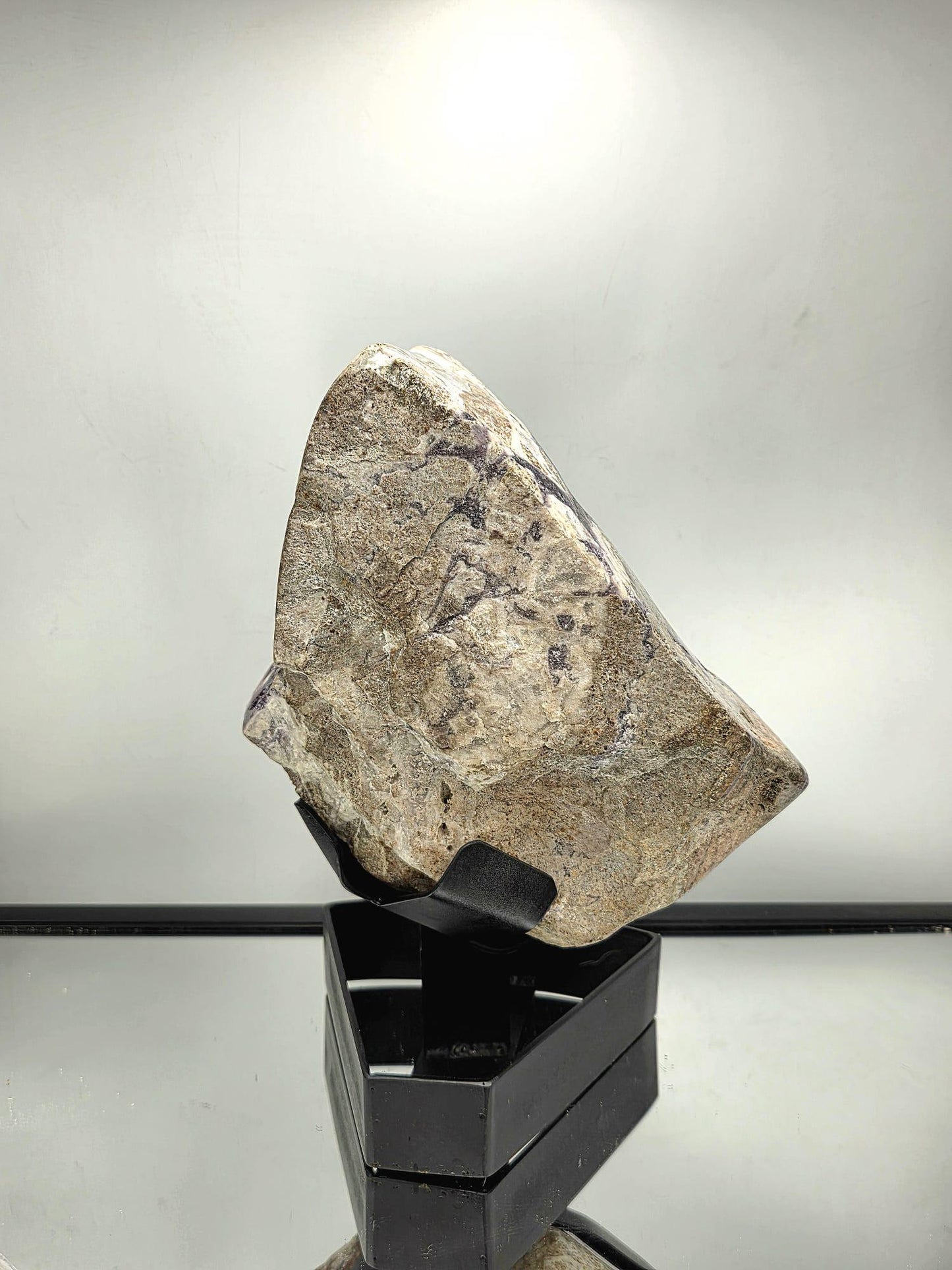 Side view of Amethyst mineral on custom display stand