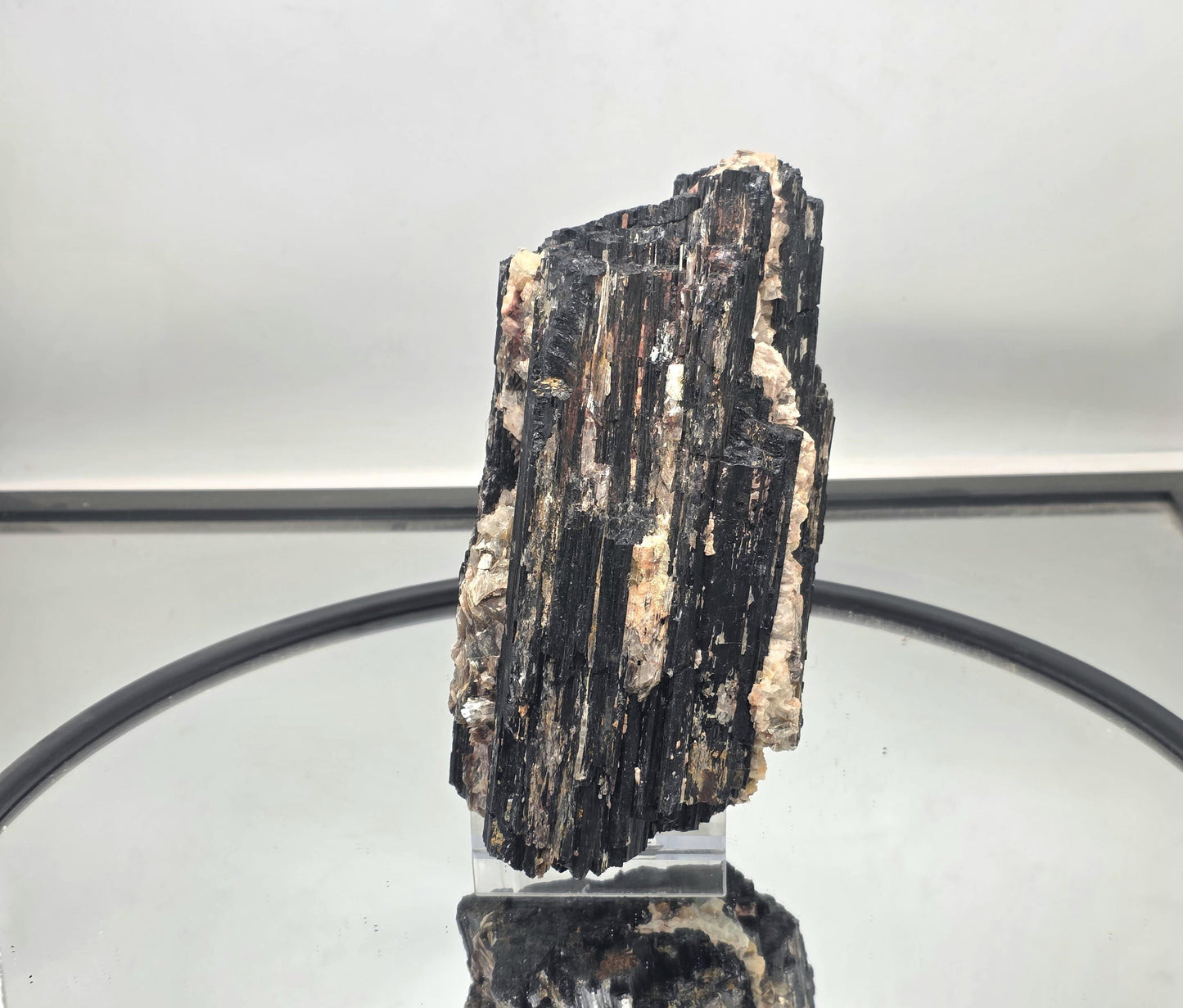 Large black tourmaline crystal featuring natural mica inclusions.