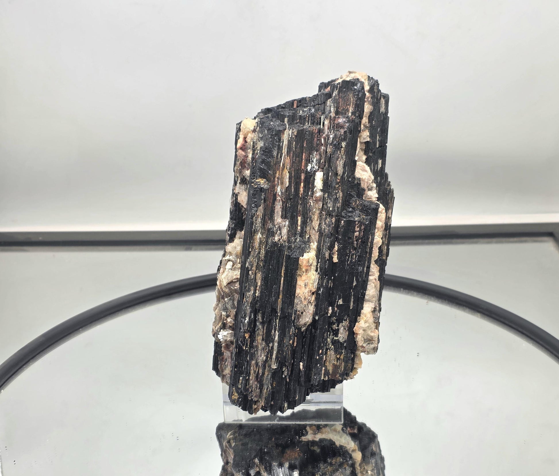 Large black tourmaline crystal featuring natural mica inclusions.