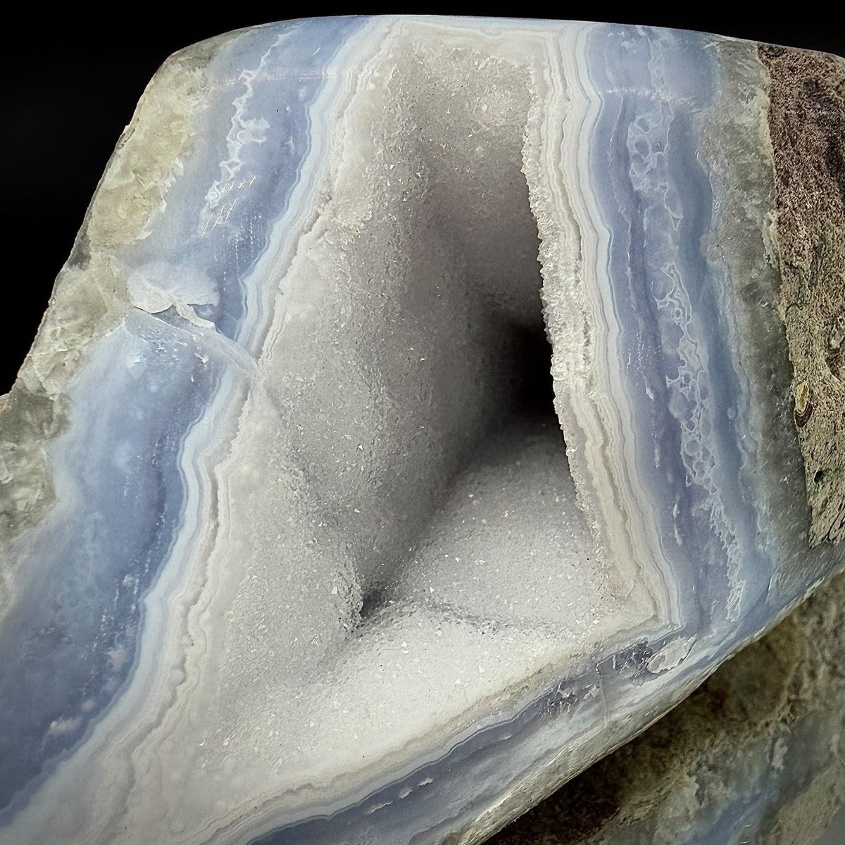 Close-up of natural sparkling druzy and layered patterning within a Blue Lace Agate geode.