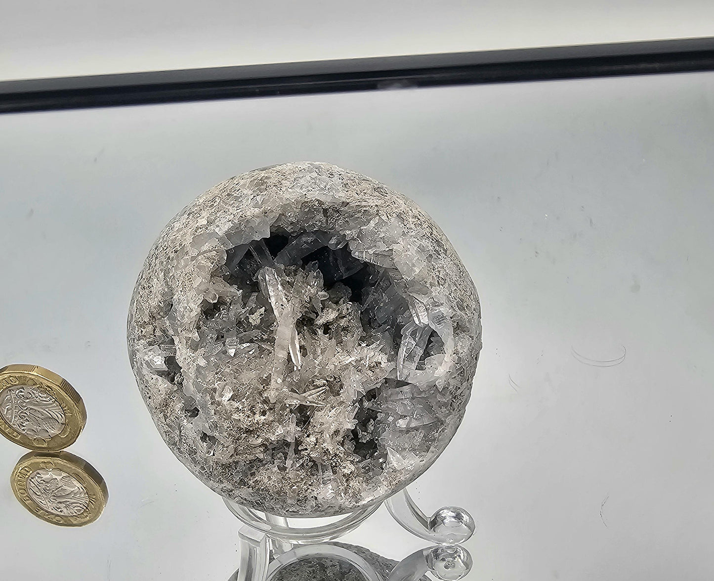 Close-up of Celestite geode sphere with fine needle crystals, showcasing its delicate, intricate pattern and serene blue color.