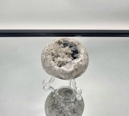 Unique Celestite geode sphere with fine needle crystals inside, displaying beautiful blue tones and intricate formations.