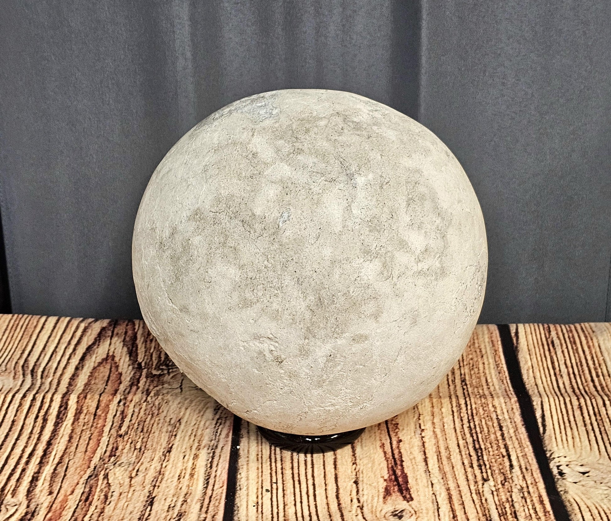 Display of large Celestite Geode Sphere, emphasizing its shimmering crystals and natural design.
