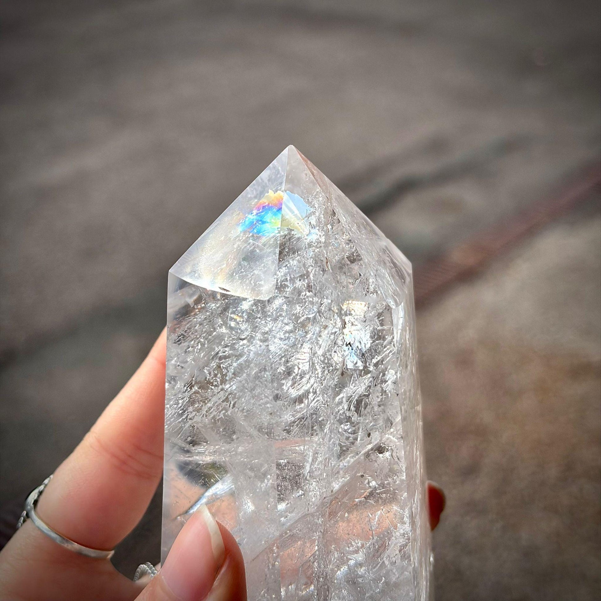 Clear quartz prism crystal tower with natural veiling, clarity and decorative display appeal.
