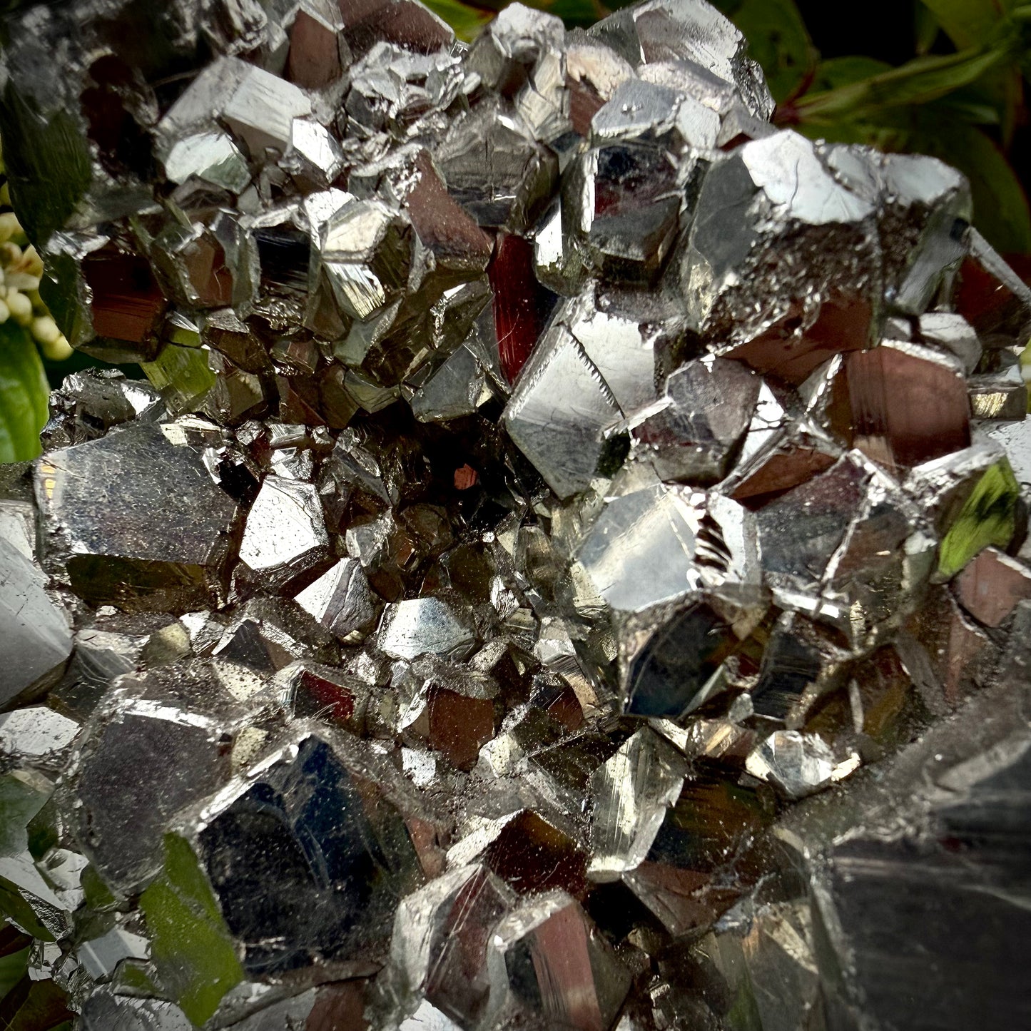Close-up of multi-faceted geometric pyritohedral crystal formations on a raw Pyrite specimen.