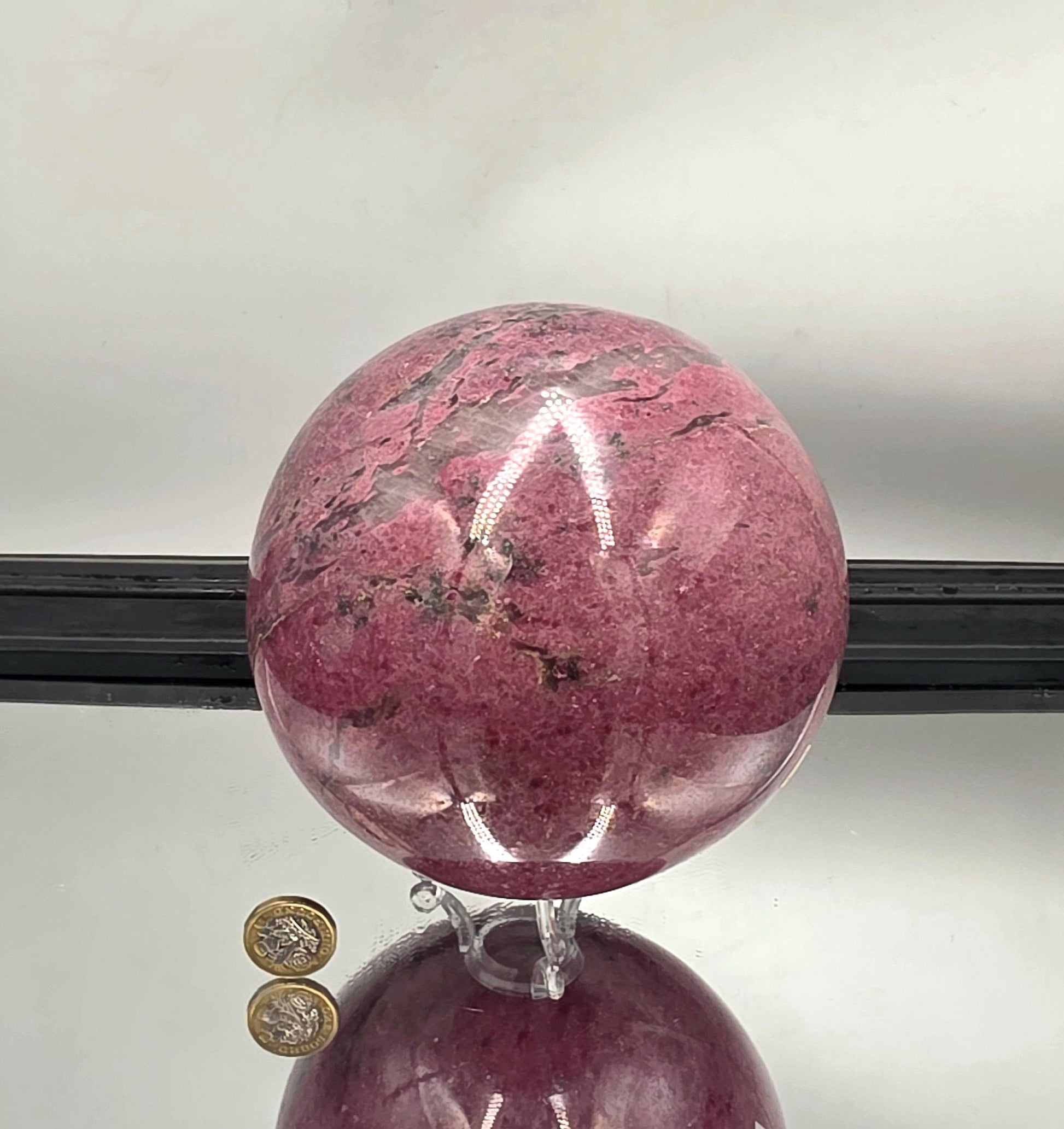 XL rhodonite sphere showcasing vivid pink and black contrasts.