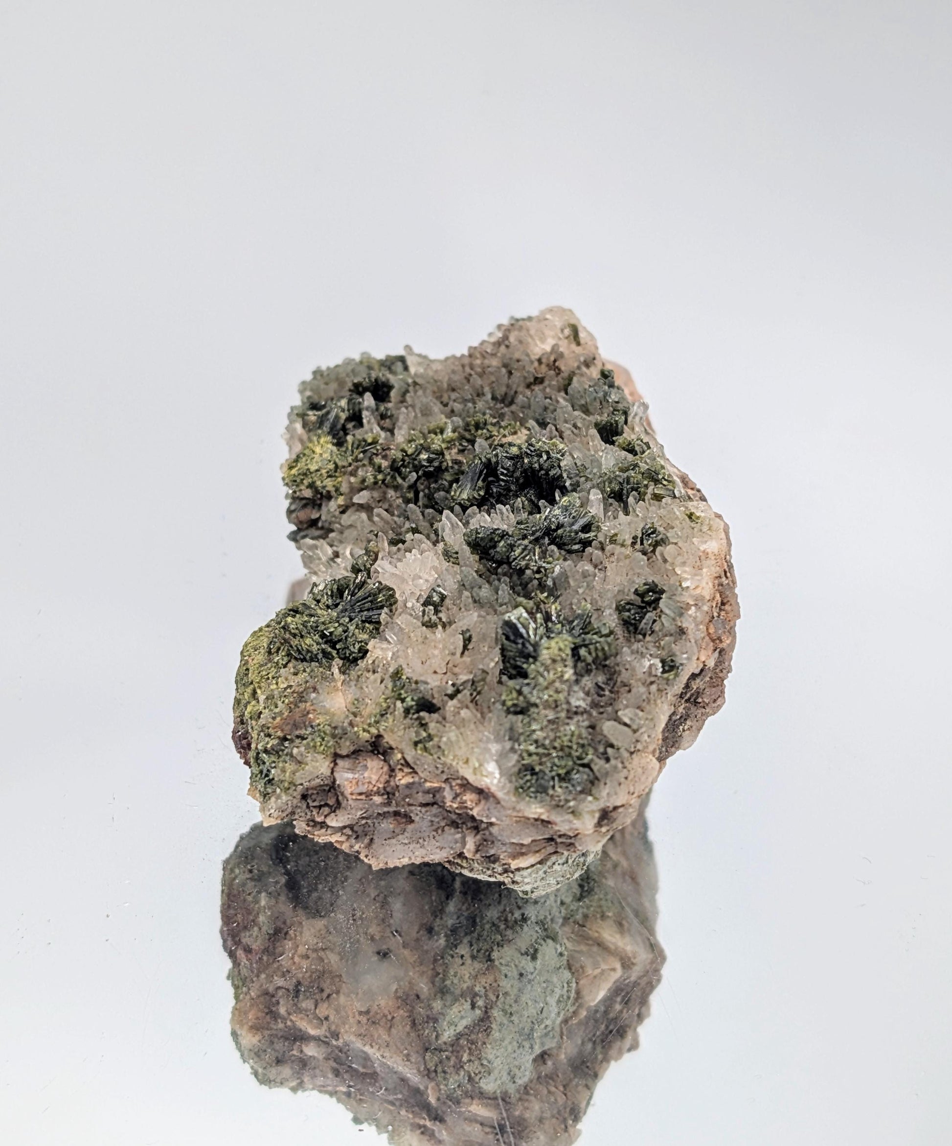 Fine mineral display of Forest Epidote on Quartz with intricate crystal formations.