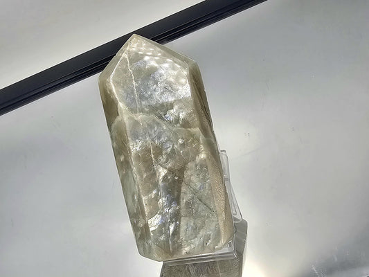 Green Moonstone crystal with vibrant garnet inclusions, sourced from Madagascar, showcasing unique color and texture.