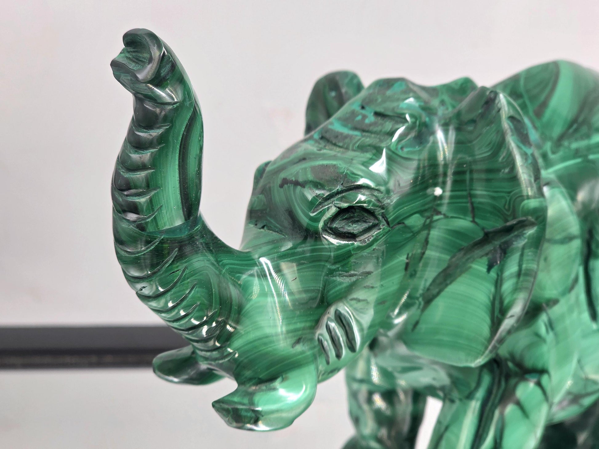 Hand-carved malachite elephant sculpture crafted from natural solid stone, highlighting deep green tones and unique patterns.