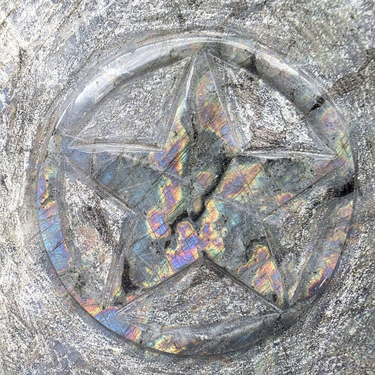Labradorite crystal sculpture featuring a carved five-pointed pentagram motif.