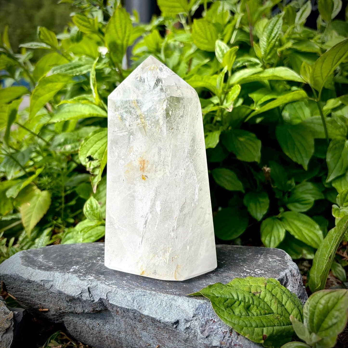 Large clear quartz crystal prism with natural veiling, clear tones and polished display finish.