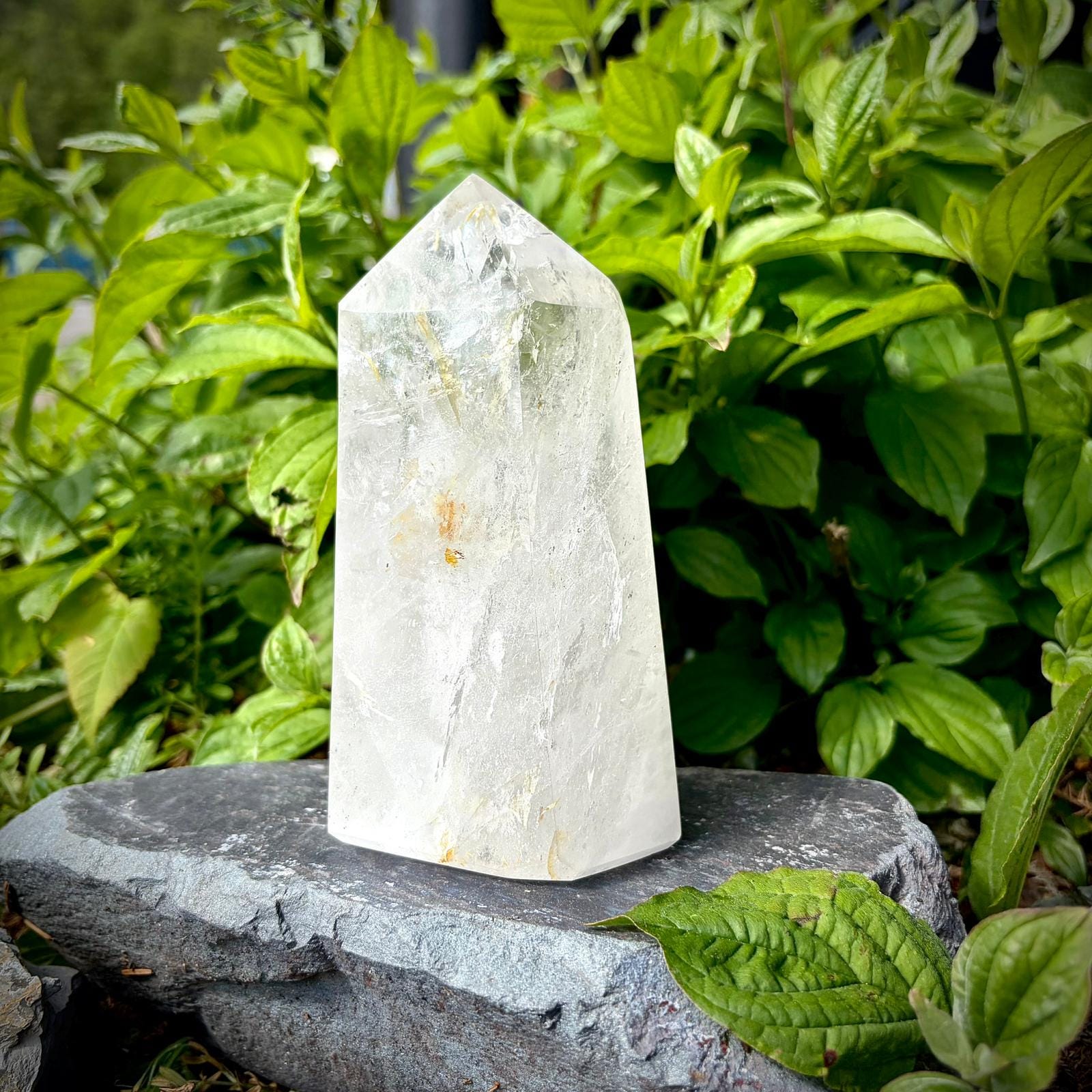 Large clear quartz crystal prism with natural veiling, clear tones and polished display finish.