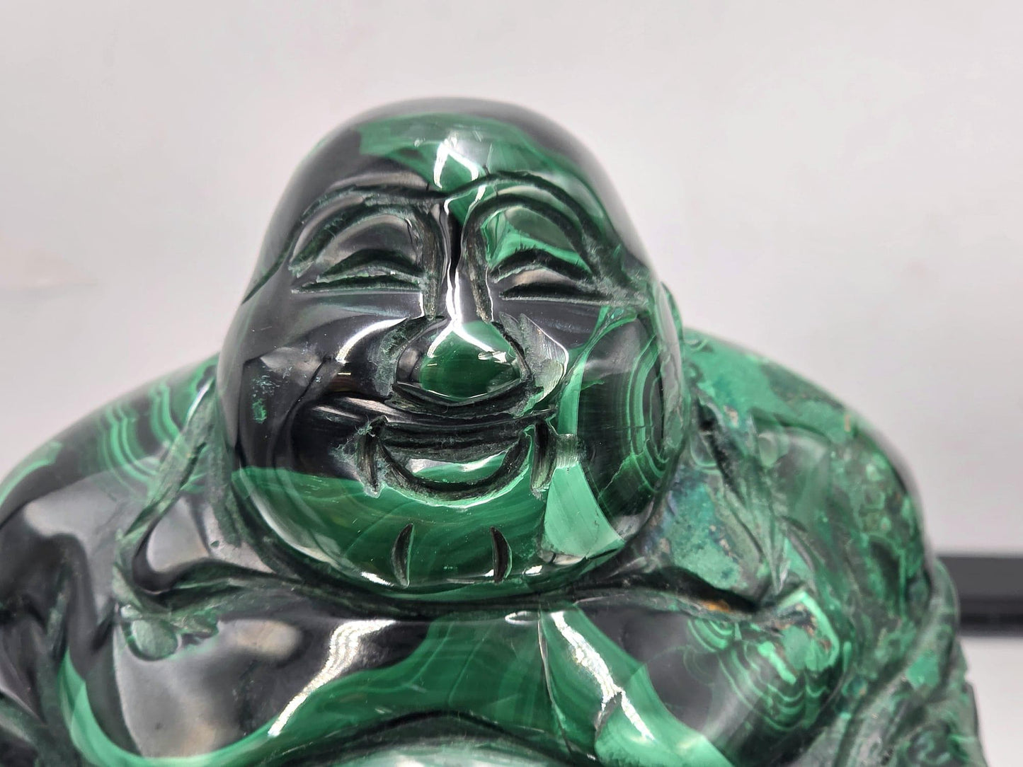 Large green Malachite Buddha carving with rich concentric patterns and polished details — a unique gemstone centerpiece.