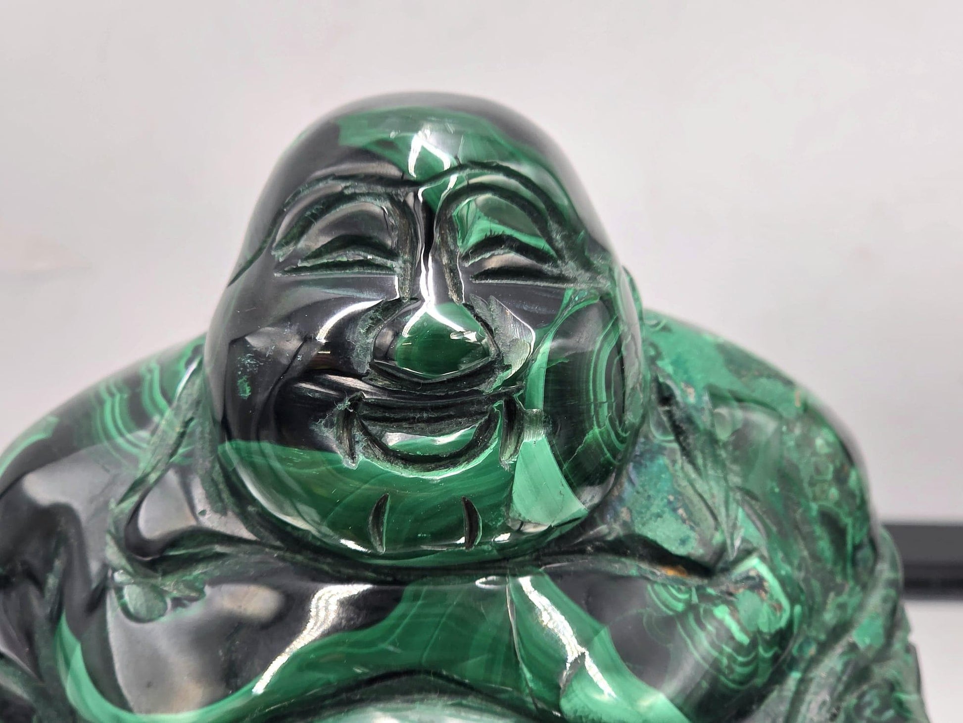 Large green Malachite Buddha carving with rich concentric patterns and polished details — a unique gemstone centerpiece.