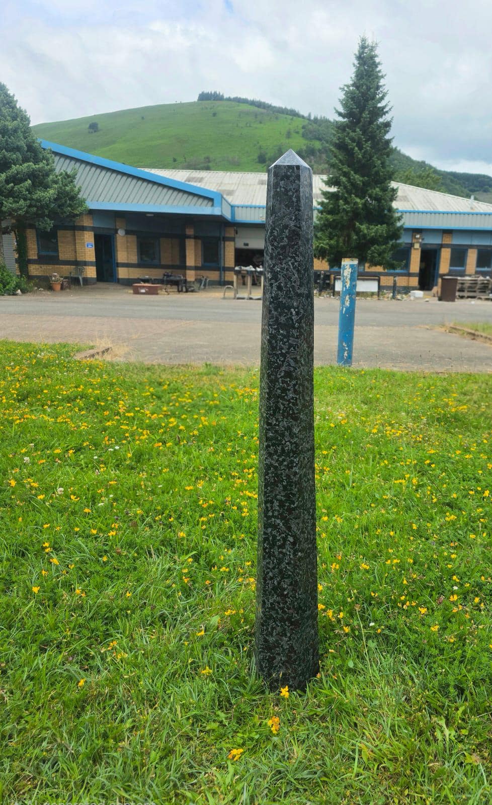 Front view of a hand-carved Madagascan Indigo Gabbro prism tower with polished faces.