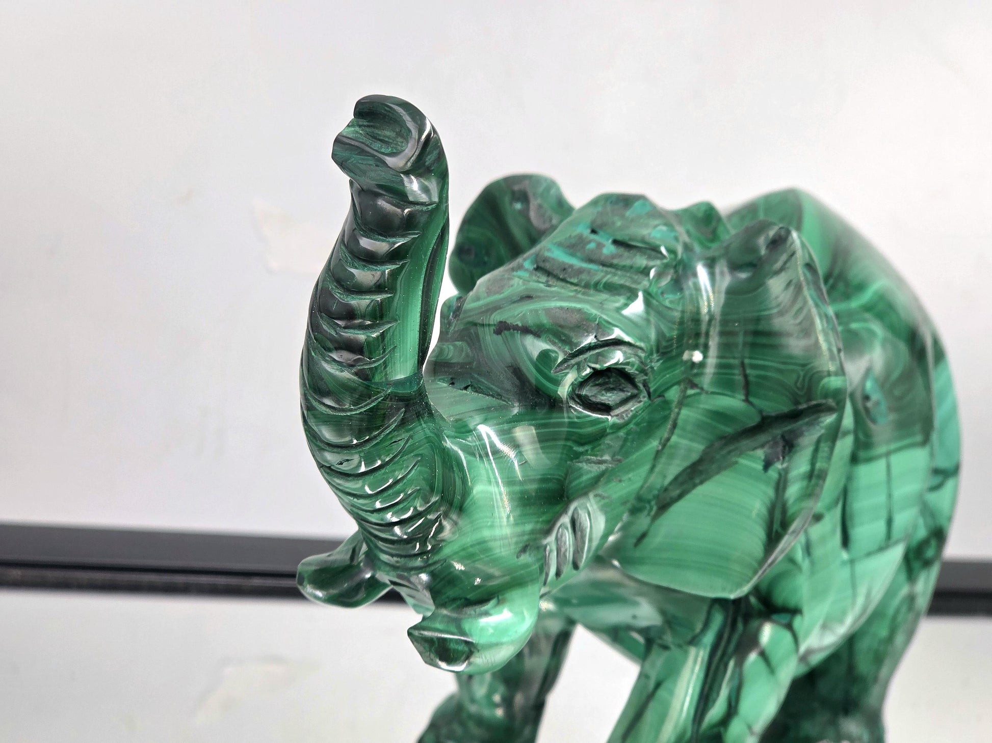 Large malachite elephant displayed on a decorative shelf as part of luxury crystal home décor styling.