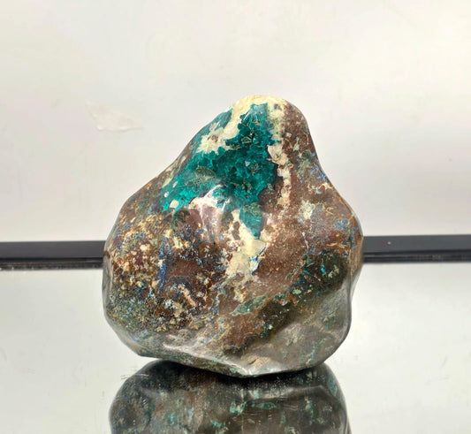 Large polished dioptase crystal specimen standing alone with vivid green color