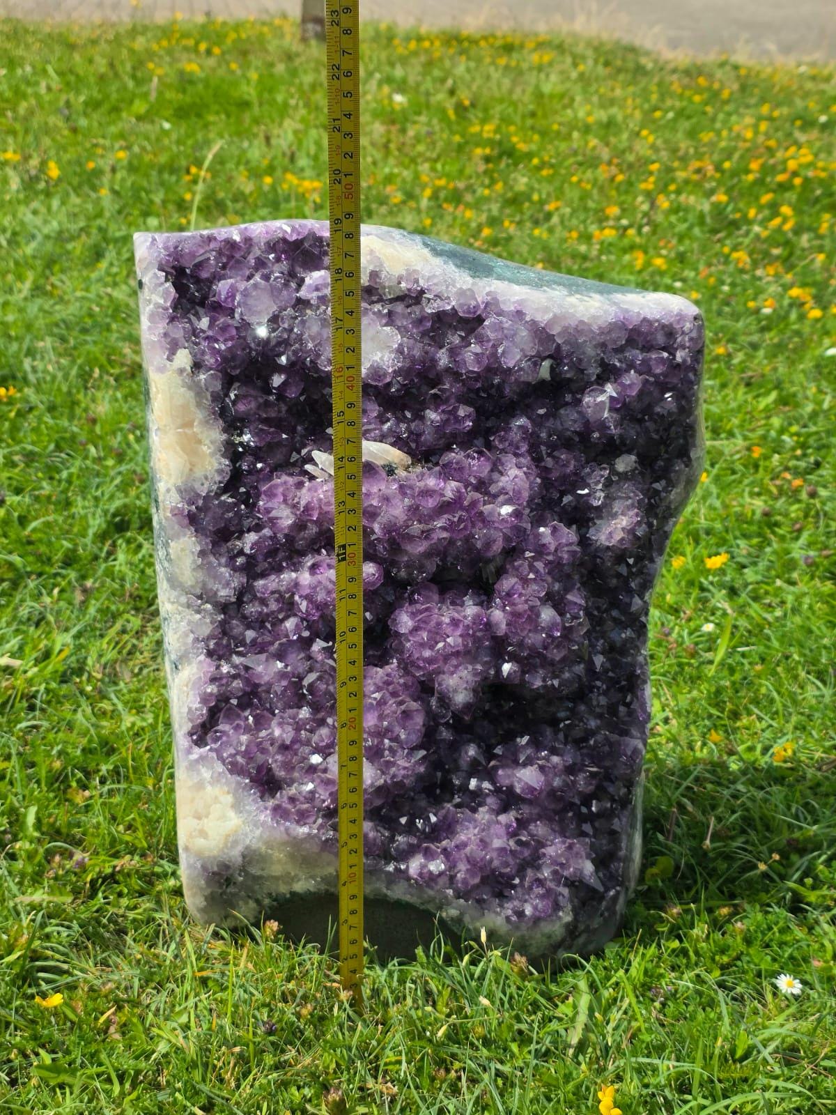 Large purple Amethyst crystal with natural formation detail and polished edge