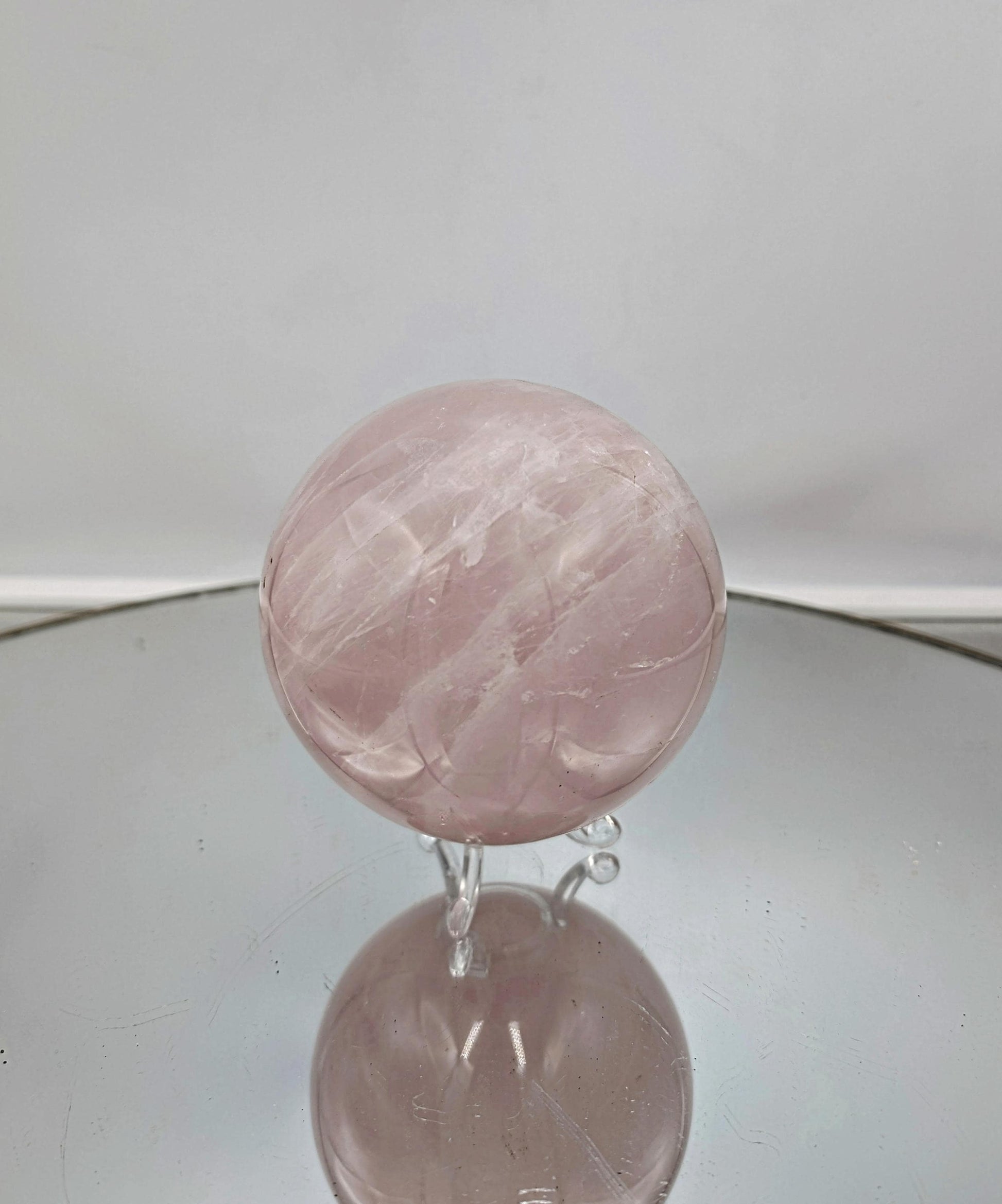 Large rose quartz crystal sphere with soft pink tones