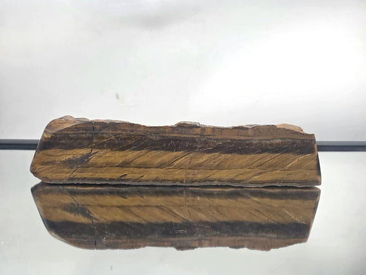 Large Tiger’s Eye crystal slice half polished and raw on white background