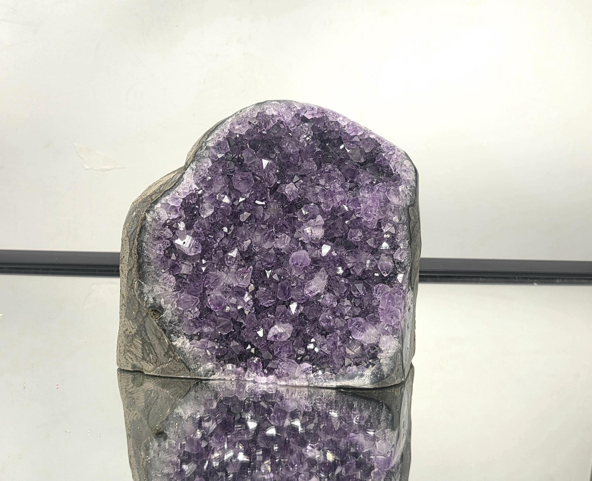 Large Uruguayan amethyst geode with deep purple crystals, natural quartz formation and display-ready cut base.