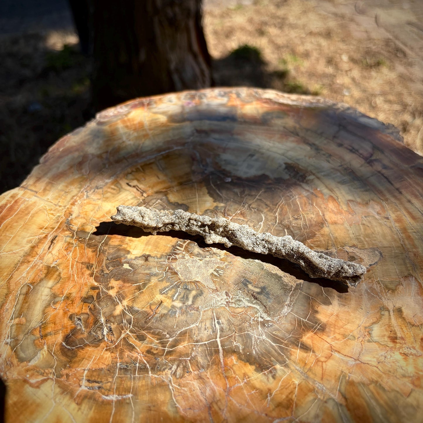 Close-up showing the natural sandy and glass-like surface of the Lightning Stone.