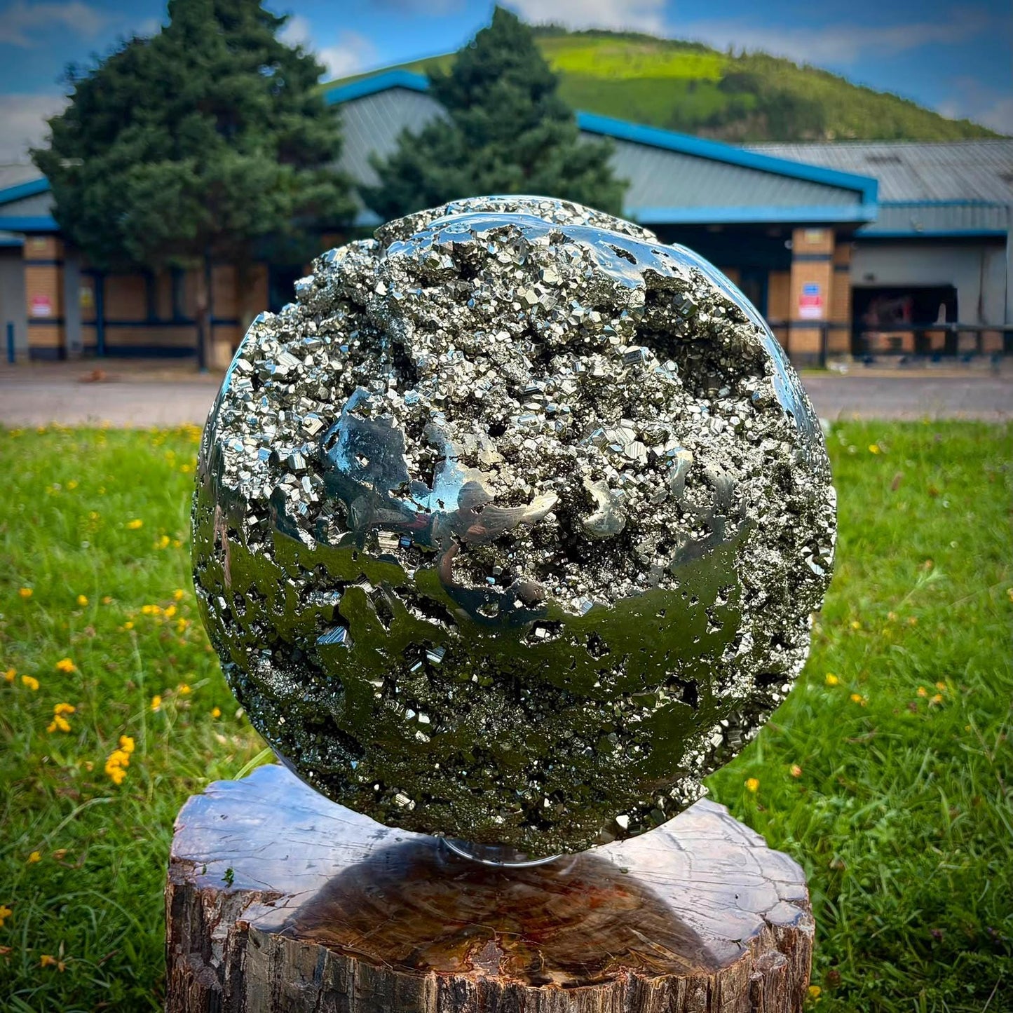 Large metallic Pyrite sphere styled on a console for luxury crystal and interior display.