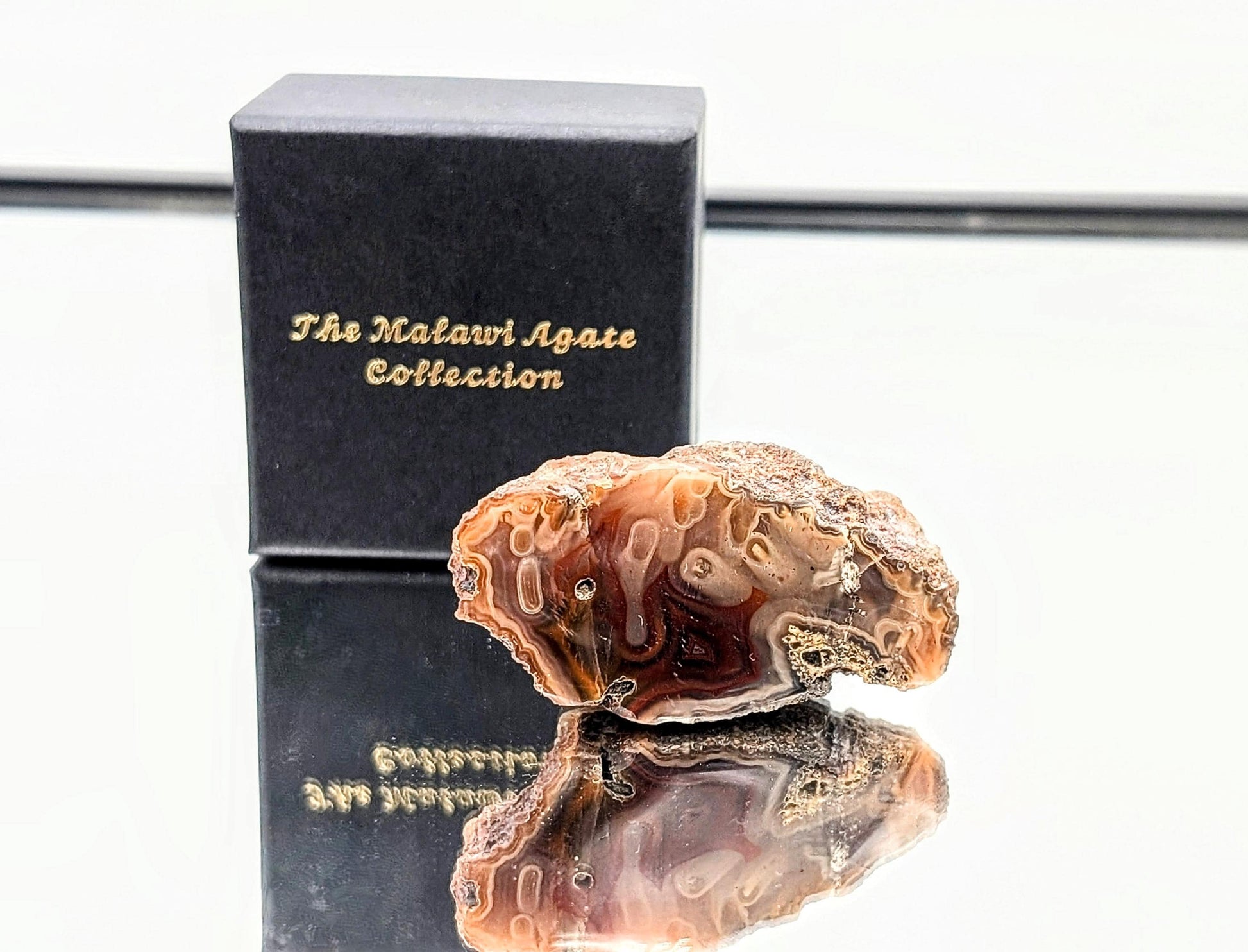 Polished Malawi Agate collection featuring vibrant color bands in a luxury presentation box.